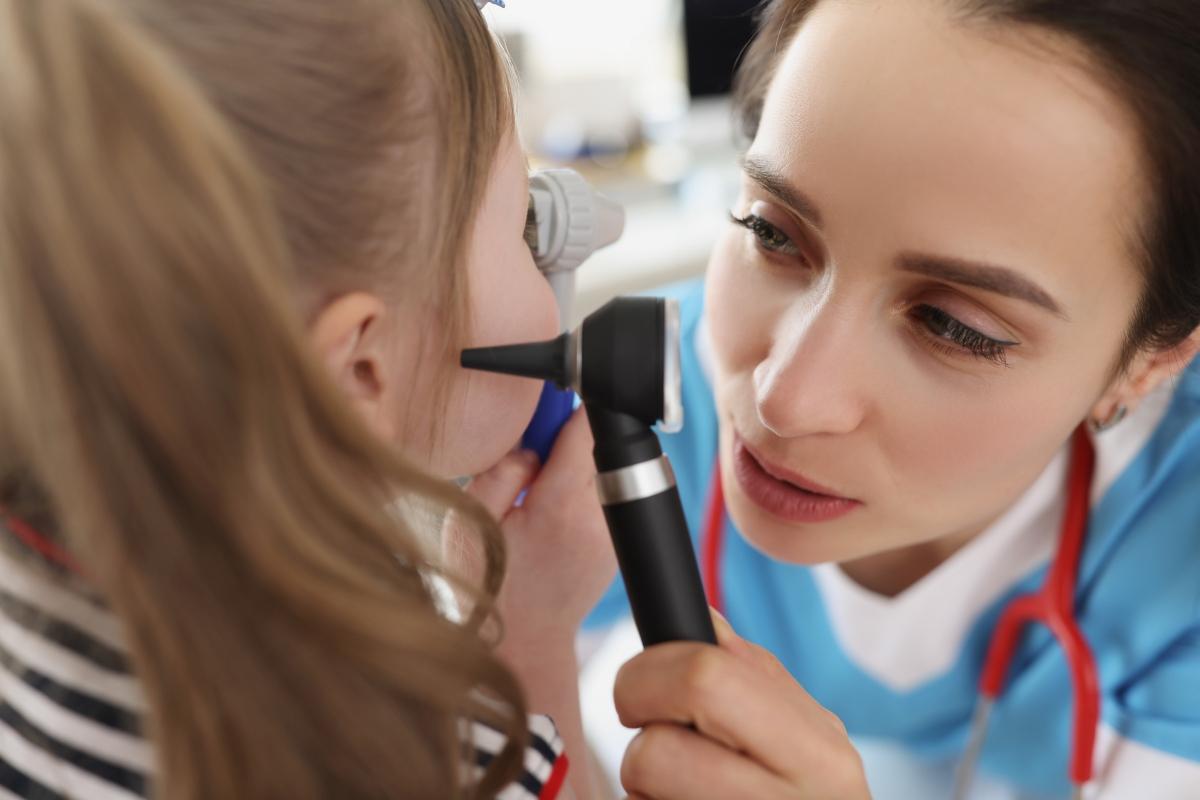 female physician examining girl's ears
