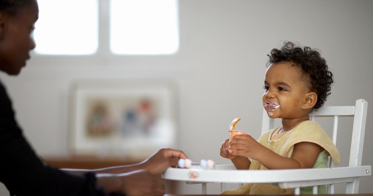 Parent feeds baby in a high chair