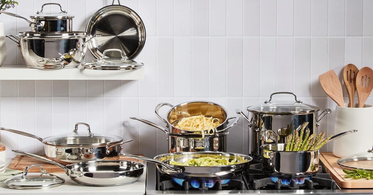 Stainless steel pots and pans cooking food in a gas stove in a white kitchen