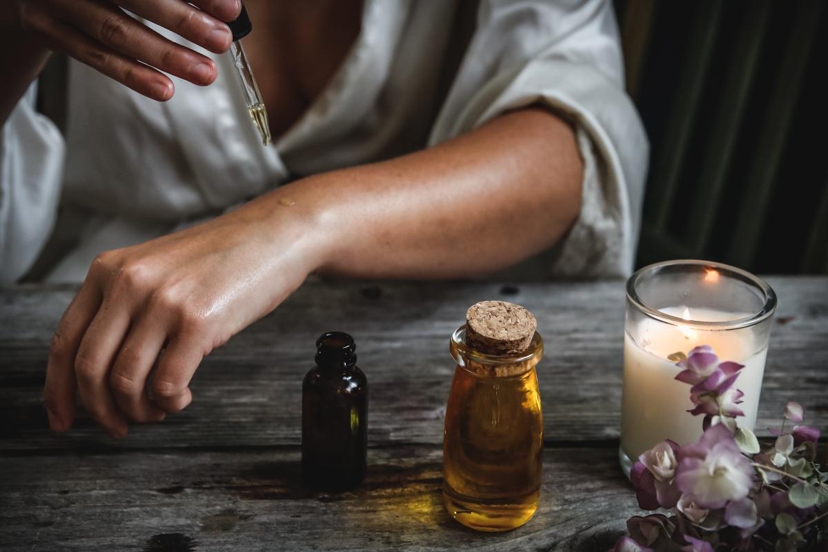 woman applying essential oil with dropper