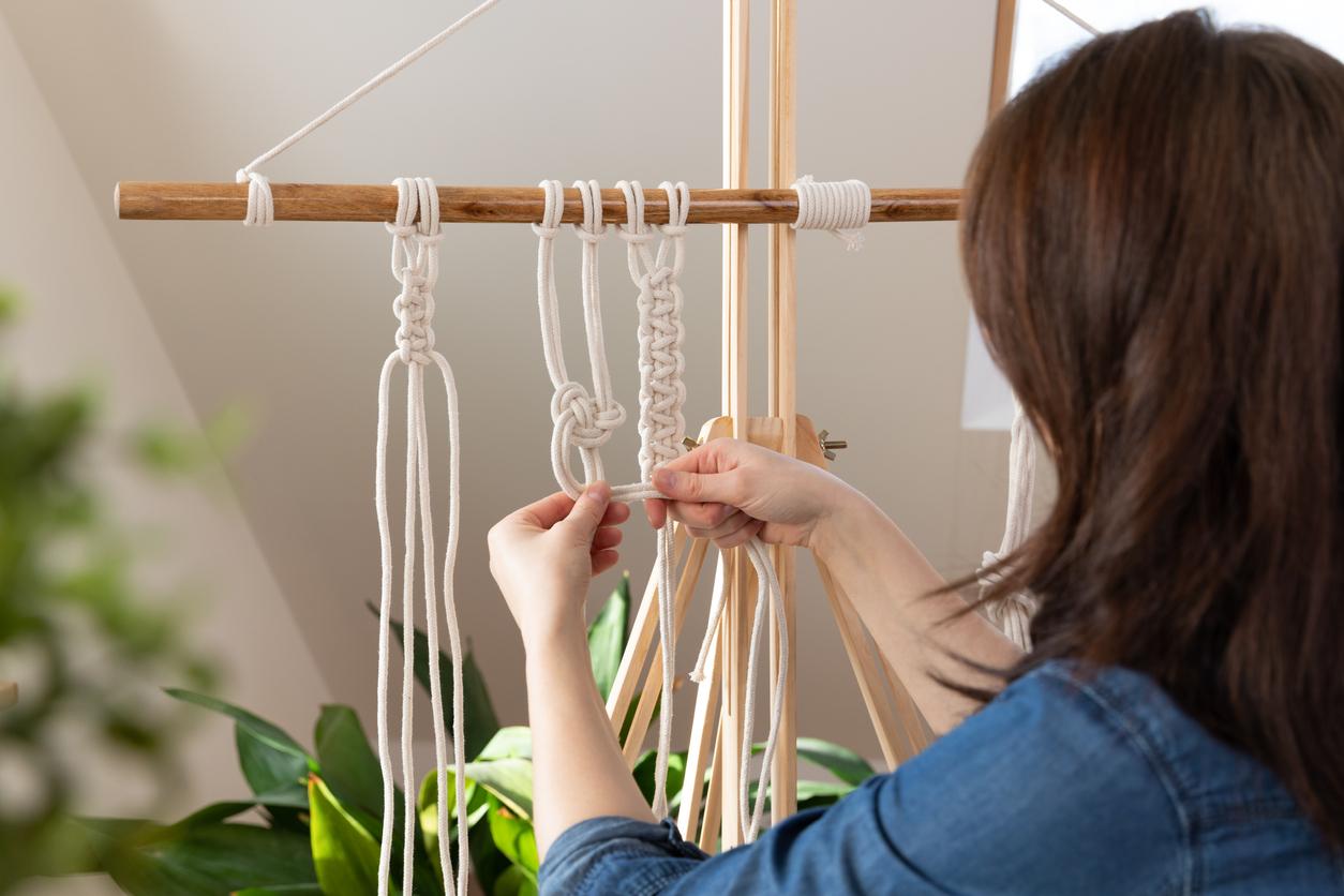 Person working on a macrame project.