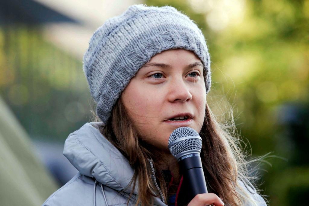 Swedish environmental activist Greta Thunberg, wearing a gray beanie, delivers a speech outside the seat of the Statkraft energy company in Oslo, Norway in October 2023.