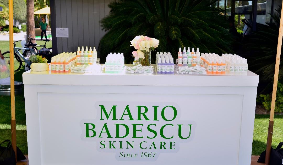 Table featuring Mario Badescu products under a tent outside 