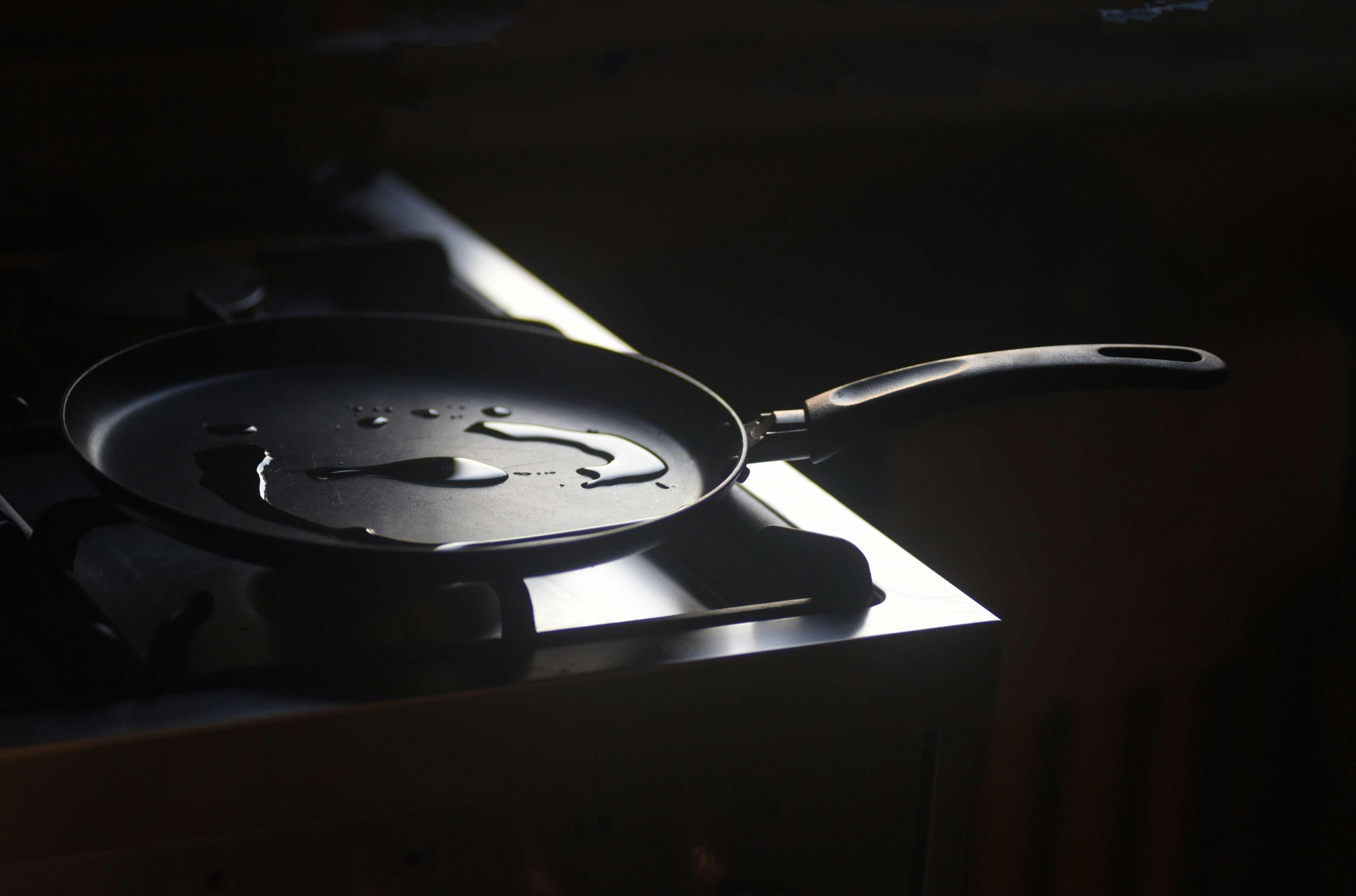 A nonstick frying pan is pictured on a stovetop.