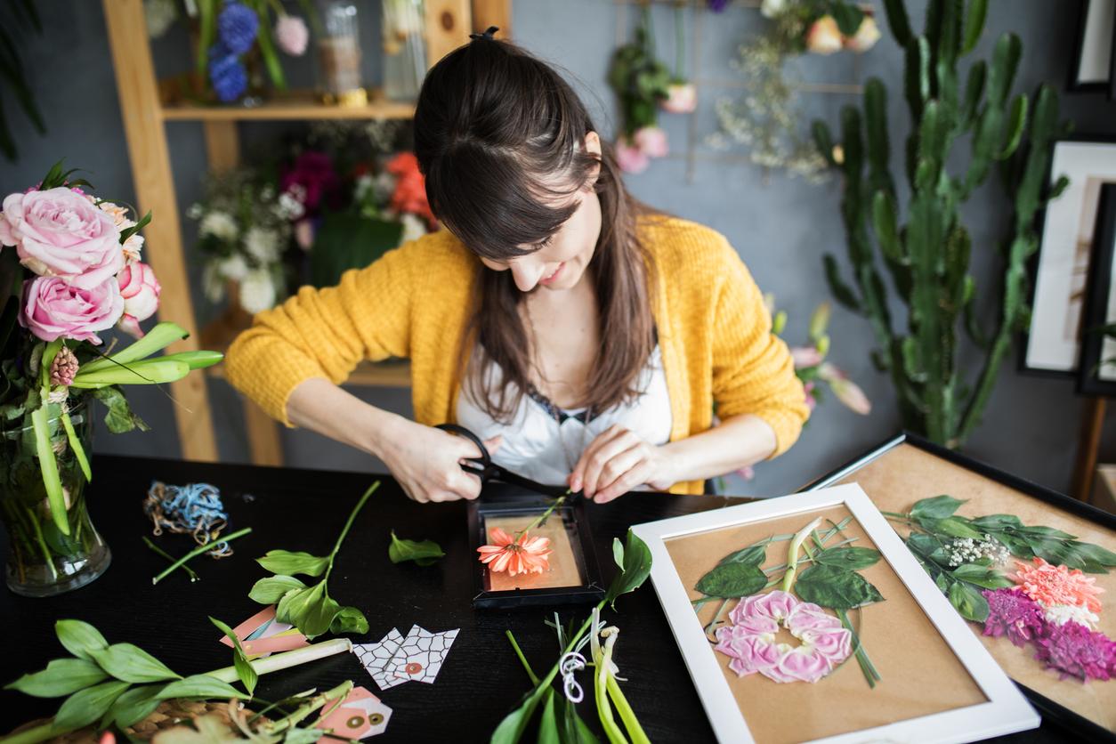 Person putting dried flowers into a frame