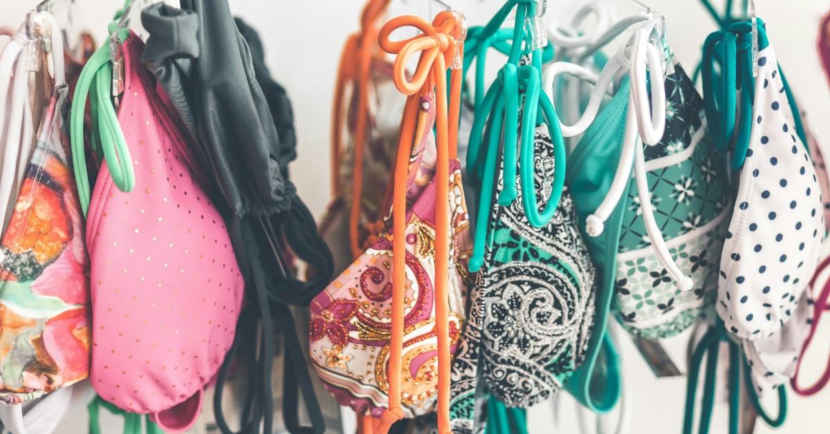 Colorful bikini tops hang from a shelf