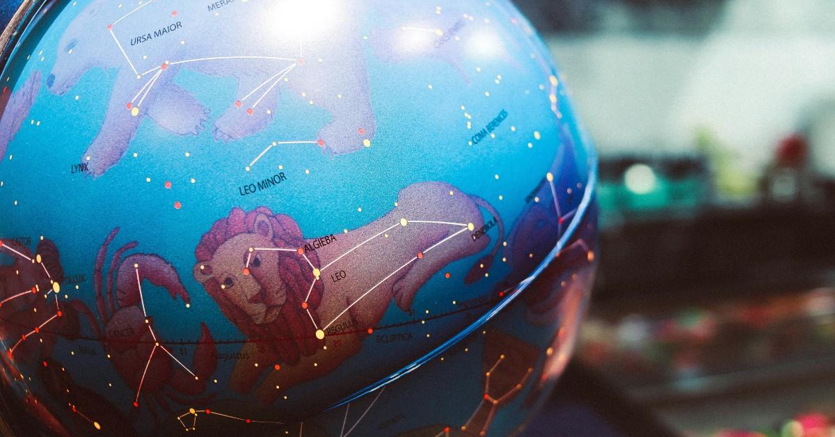 Closeup of a globe that is decorated with the zodiacs 