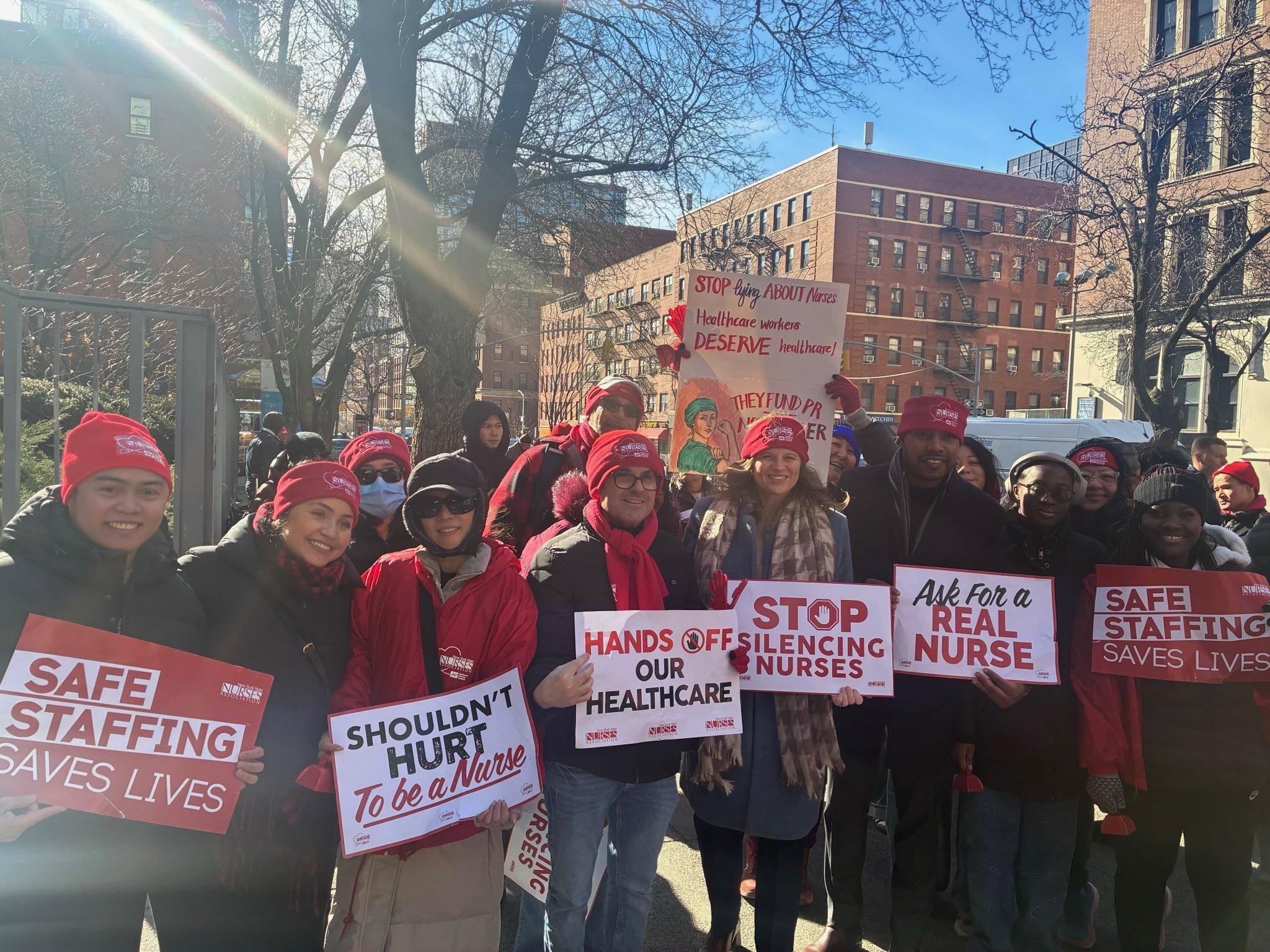 Nurses from the New York State Nurses Association are pictured holding picket signs.