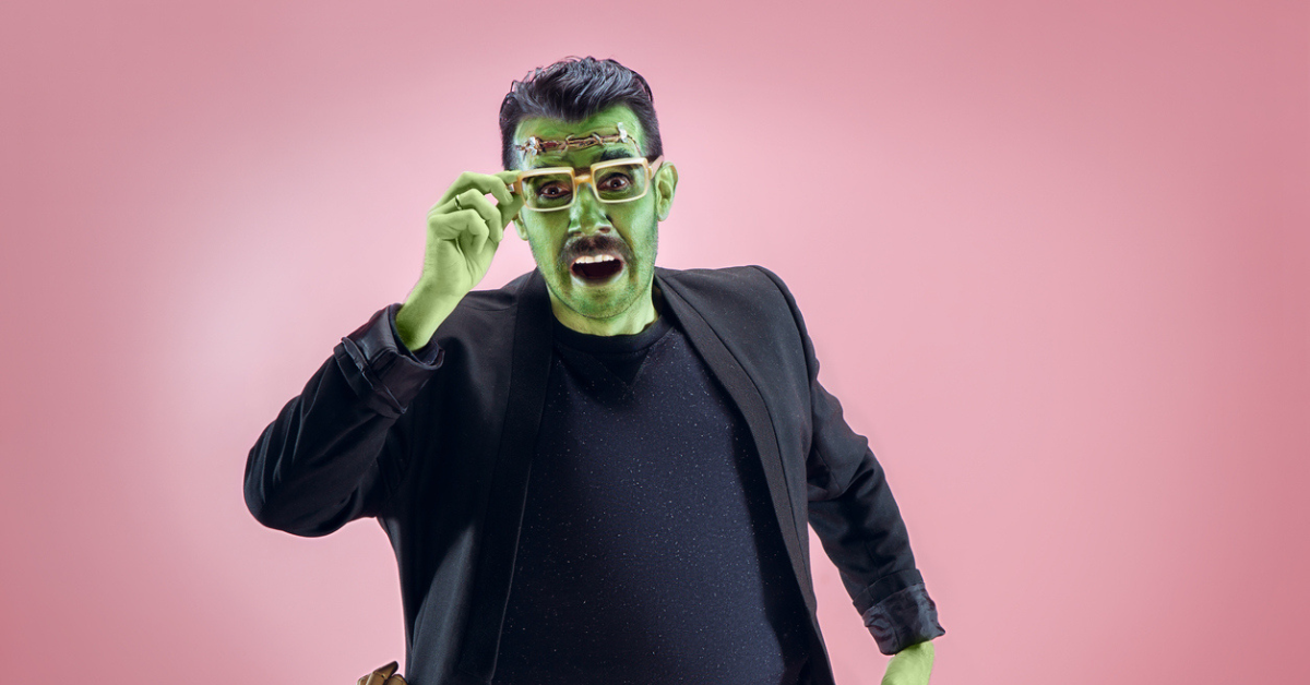 A man paints his face green and wears a black shirt and jacket to dress like Frankenstein's monster