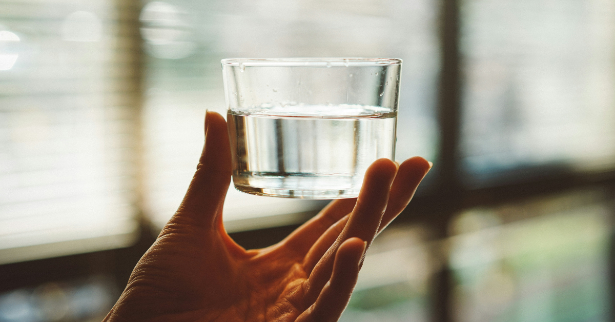 A person holds a water sample up